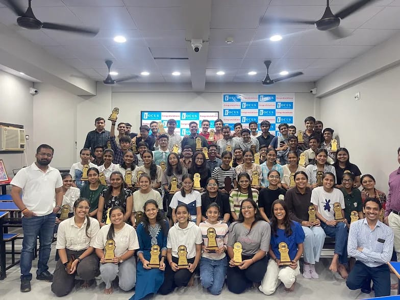 Focus CA Coaching students celebrating CA Foundation results with trophies